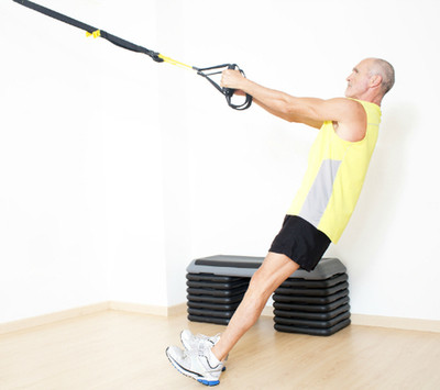 Picture of an older adult exercising on a suspension trainer.