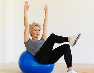 Image of a senior woman exercising on a gym ball.