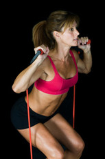 Image of a woman training with exercise tubings in a mobile setting.