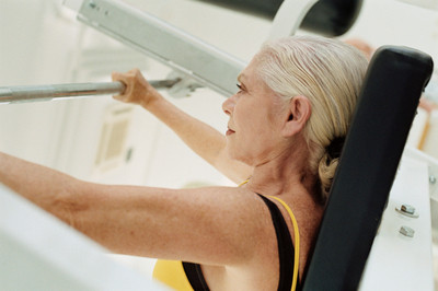 Image of a mature lady performing muscle-building exercises.