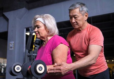 Image of a senior-aged personal trainer working with an older adult client.