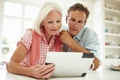 Image of a middle-aged couple looking at their online personal training programs.